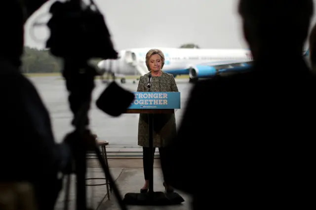 U.S. Democratic presidential candidate Hillary Clinton pauses as she speaks to the media before boarding her campaign plane at the Westchester County airport