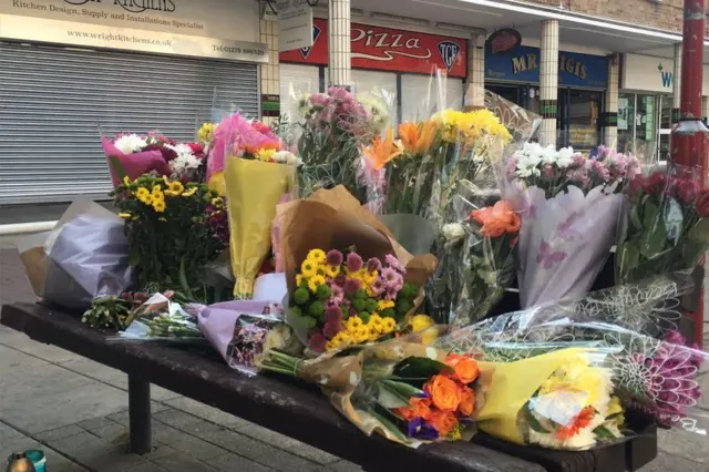 Bunches of flowers on a bench at The Stow