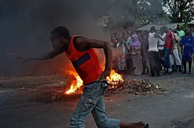 Protesters in front of a burning barricade