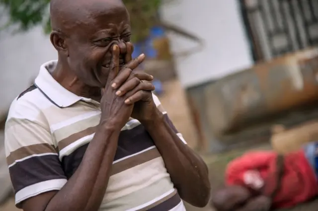 man cries outside opposition HQ, while another lies injured in the background