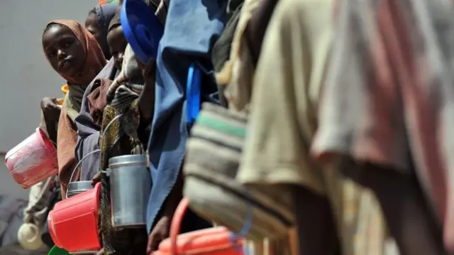 Women queue for water with buckets