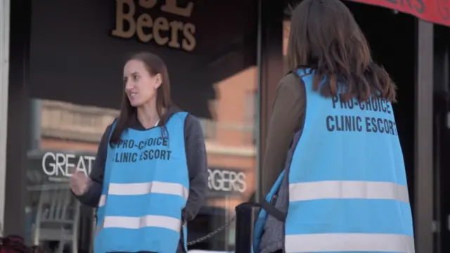 Escorts like Julie Anne Zimny shield patients from protesters as they walk in