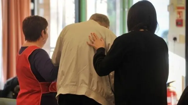 Man being helped by two women