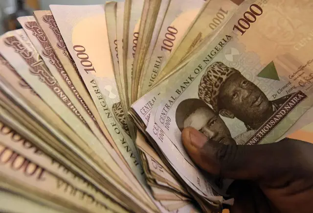 Someone holding naira notes in Lagos, Nigeria