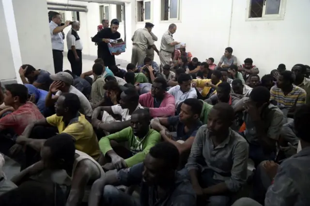 Survivors from the boat disaster sit on a police station floor, Egypt