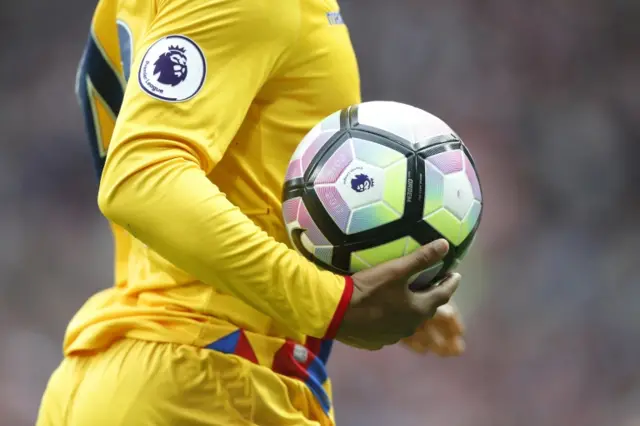 A footballer holds a ball