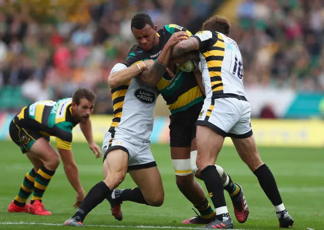 Courtney Lawes wrapped up in a tackle by Wasps players