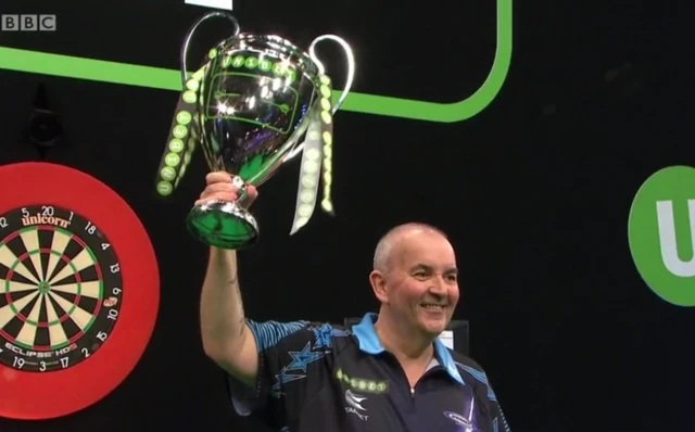 Phil Taylor lifts the trophy