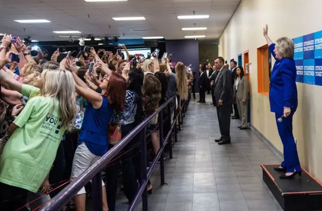 the crowd turns their back on Mrs Clinton to take a selfie