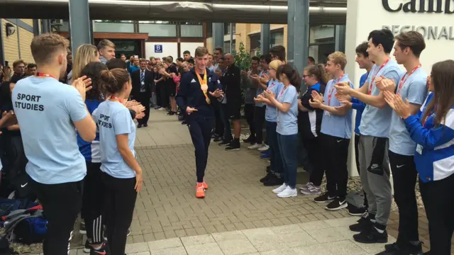 Louis Rolfe walks through a group of students