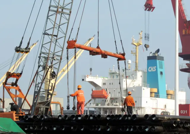 Chinese workers load steel pipes at a port in Lianyungang in east China"s Jiangsu province on September 8, 2016.