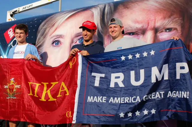 Trump suporters pose for a picture next to a banner at Hofstra University.