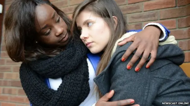 Woman comforting young woman