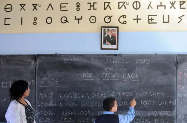 A school teacher helps a pupil reads a text in Amazigh, an ancient tongue, on September 27, 2010 in Rabat.