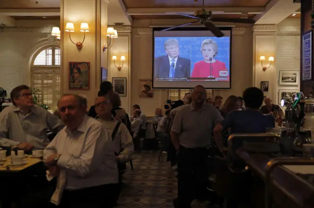 People watch live broadcasting of the U.S. presidential debate between Democratic presidential nominee Hillary Clinton and Republican presidential nominee Donald Trump, at Foreign Correspondents" Club in Hong Kong, Tuesday, Sept. 27, 2016