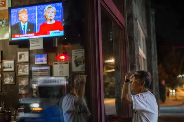 A man watches the debate through the window of a pub in Atlanta