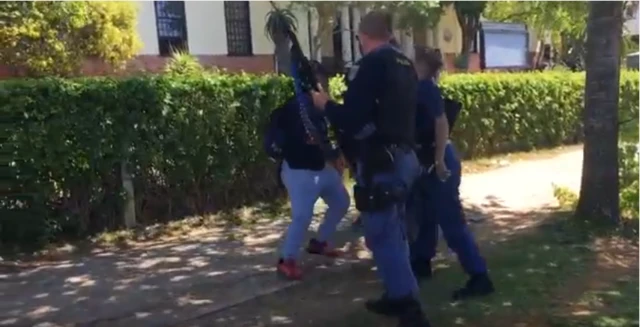 .Police confront one of the students. She reacts furiously after being showed by one of the officers.