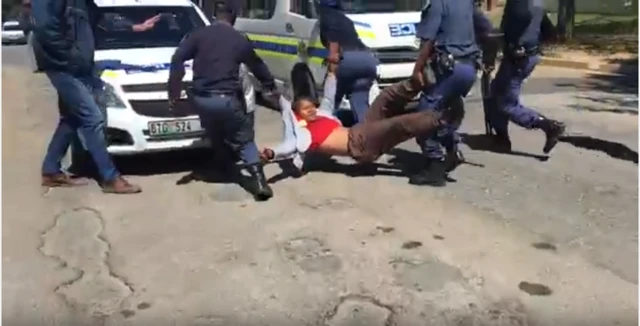 .More police officers join in carrying the student to the police van