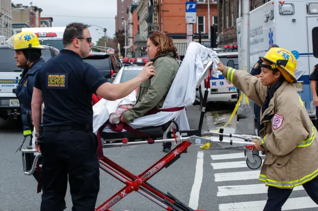 Emergency workers help an injured person at New Jersey Transit"s rail station in Hoboken.