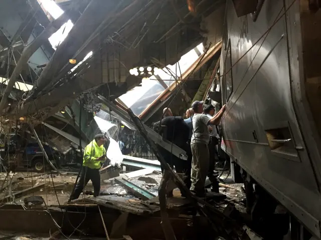 Train personel survey the NJ Transit train that crashed in to the platform at the Hoboken Terminal