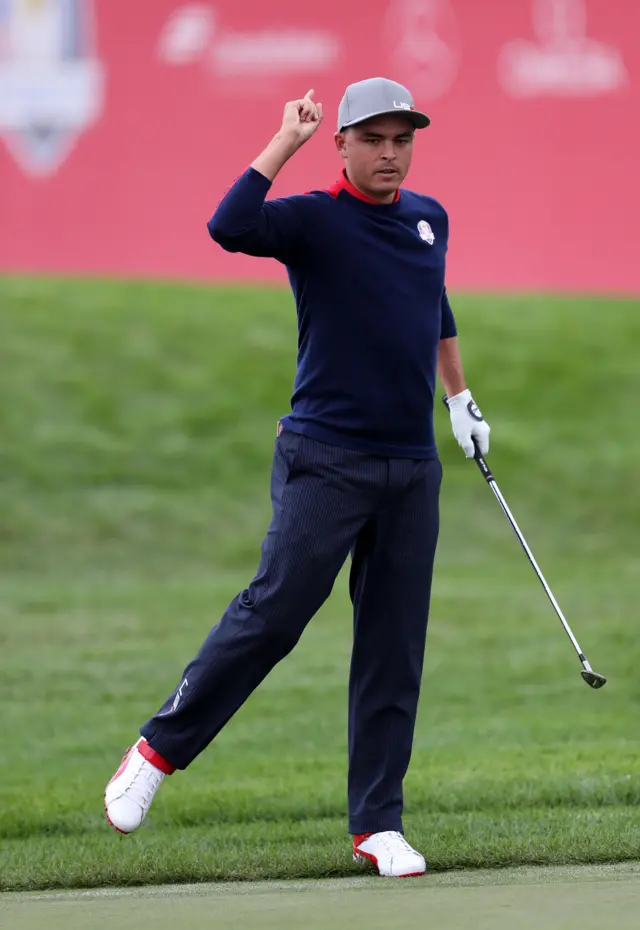 Rickie Fowler celebrates chipping in at the ninth