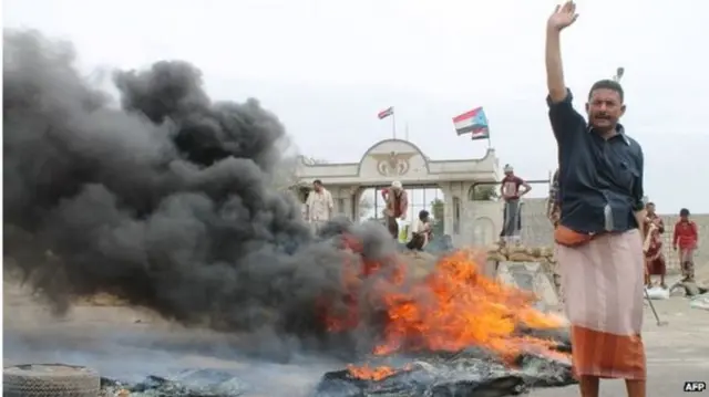 Man stands by fire in Yemen