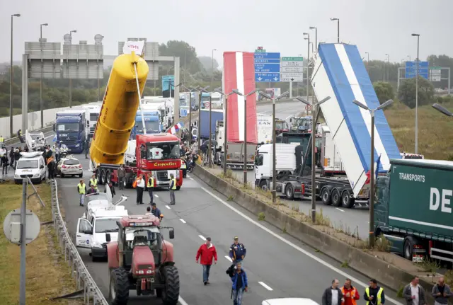 Harbor workers, truck drivers, farmers, storekeepers and residents attend a protest demonstration on the motorway against the migrant situation in Calais, France,