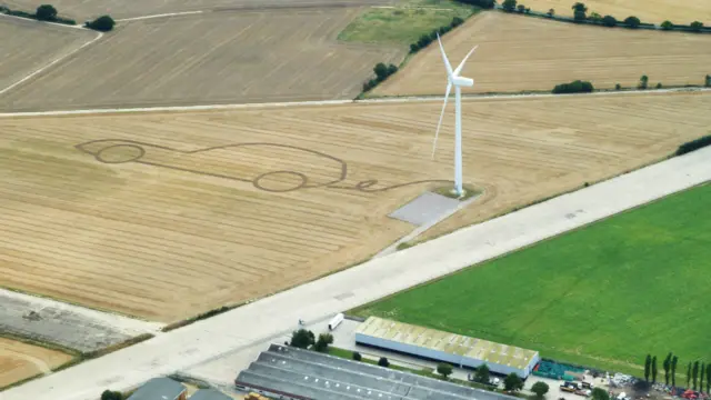 Land art in field next to turbine