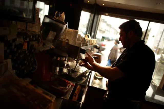 A waiter makes drinks in the Atlas cafe in Leyton