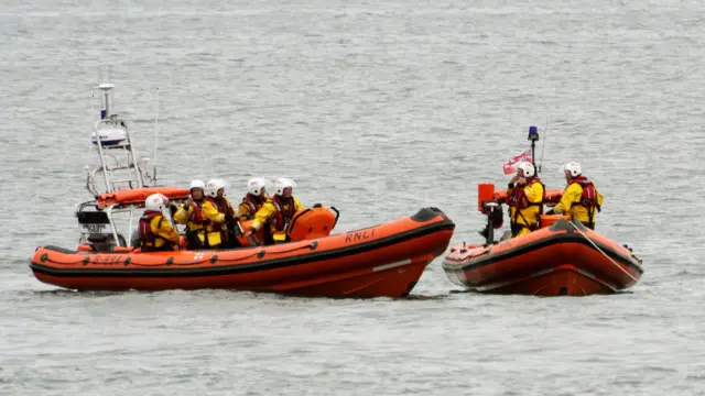 Looe lifeboats old and new next to each other in the water