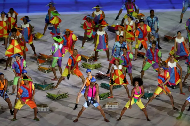 Dancers at the Rio Maracana, dressed in bright colours on a beach