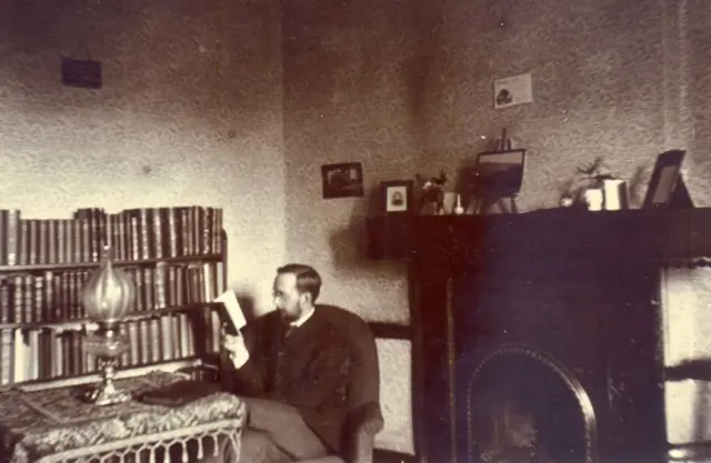 St John's College student in room, 1900