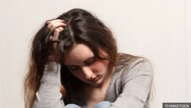 Teenager with head in her hands