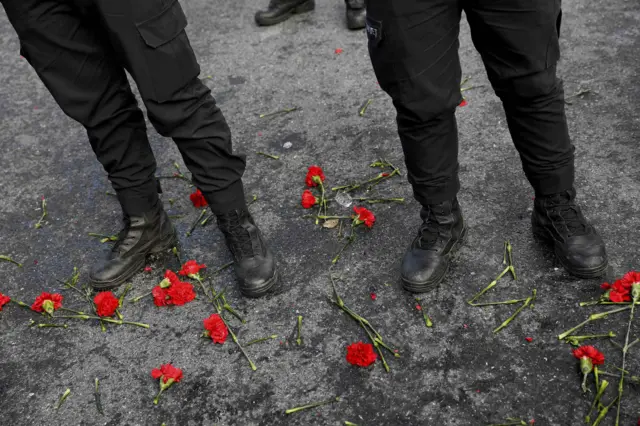 Flowers are placed next to Turkish police officers as they stand guard near the Reina nightclub, which was attacked by a gunman, in Istanbul