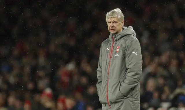 Arsene Wenger stands on the side line