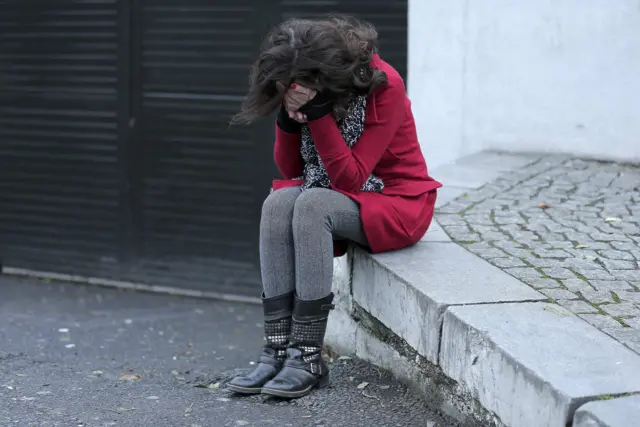 A woman mourns with her head in her hands