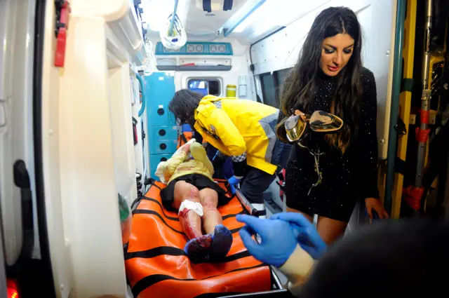 An injured woman is carried to an ambulance from a nightclub where a gun attack took place during a New Year party in Istanbul, Turkey, January 1, 201