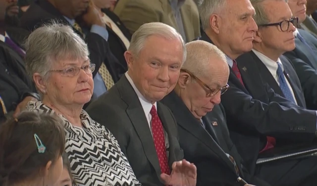 Sen Jeff Sessions (centre) waves to a girl in the hall