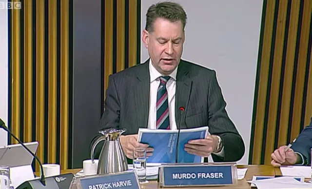 Tory MSP Murdo Fraser clutches the draft budget document