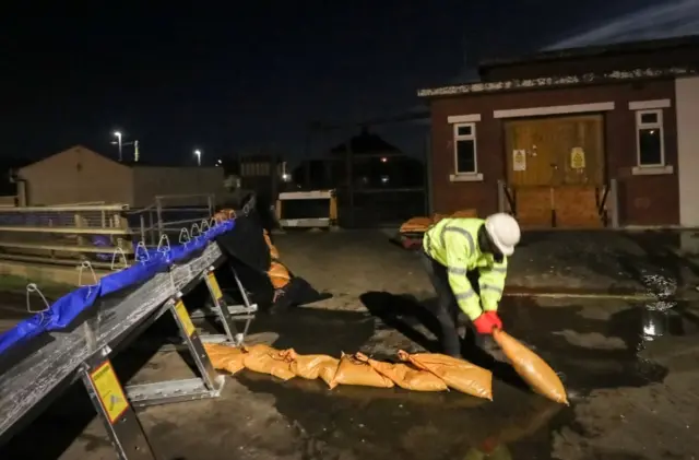 A member of the Environment Agency building flood defences