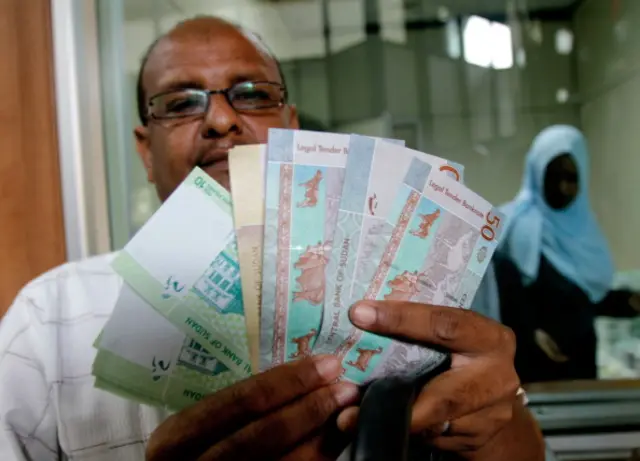 Collection: AFP A Sudanese man shows freshly-minted notes of the new Sudanese pound in Khartoum on July 24, 2011 as the country issues new currency following the South's secession from the north