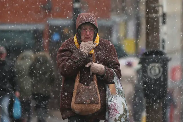 A woman makes her way up the highstreet in the snow in Harwich, southeast England