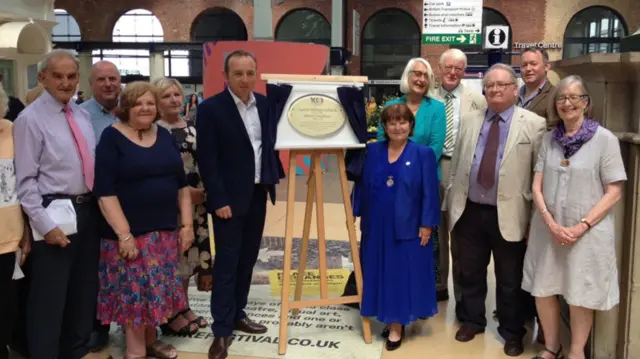 Photo of a plaque being unveiled