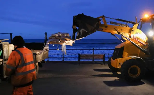 Workers from Redcar and Cleveland council unload sandbags near to waterfront shops and businesses ahead of expected high seas.