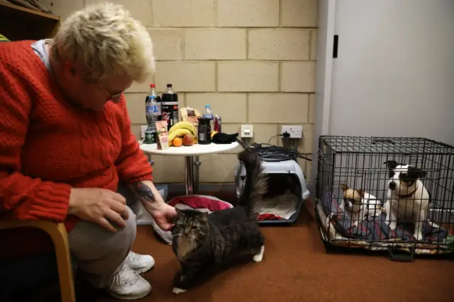 A woman with her pets in the rest centre in Jaywick