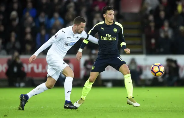 Arsenal"s Mesut Ozil in action with Swansea City"s Gylfi Sigurdsson