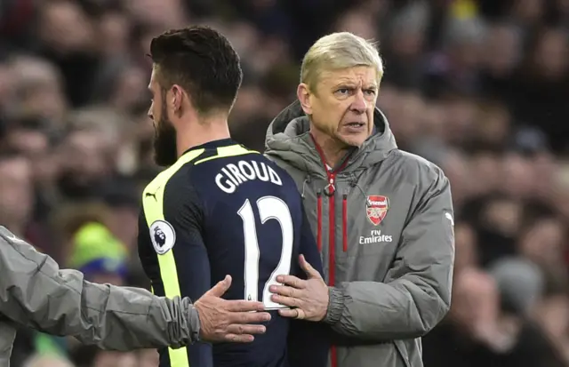 Arsenal"s Olivier Giroud walks past manager Arsene Wenger as he is substituted