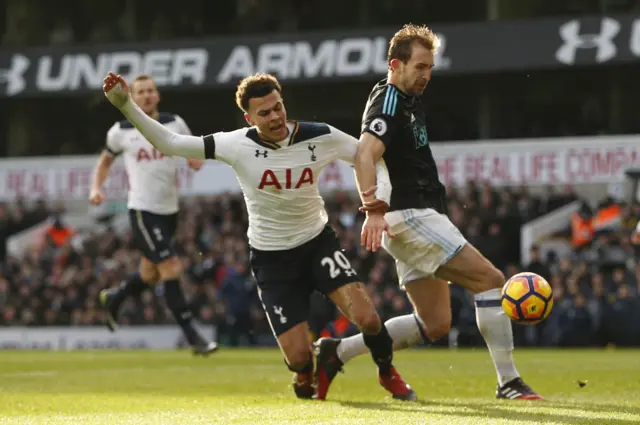 Dele Alli goes down under a challenge from Craig Dawson