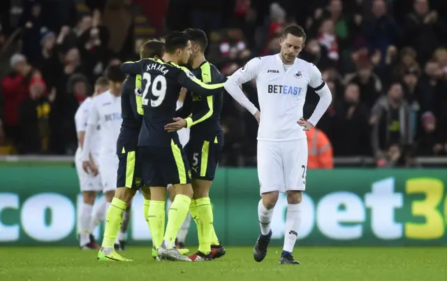 Swansea City"s Gylfi Sigurdsson looks dejected after Arsenal score their second goal