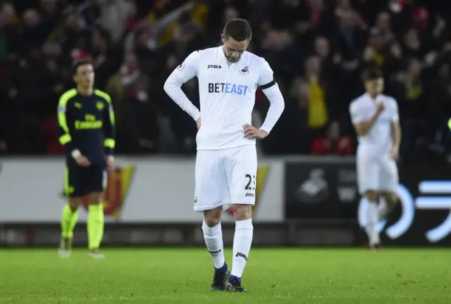 Swansea City"s Gylfi Sigurdsson looks dejected after Arsenal score their third goal